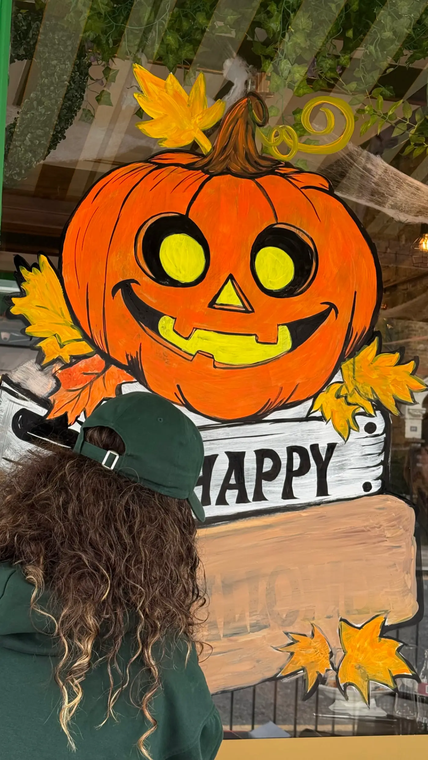 Hand-painted Halloween pumpkin window mural on a London cafe